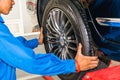 Mechanic removing or replacing car wheel at car service garage