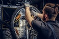 Mechanic repairing bicycle wheel tire in a workshop. Royalty Free Stock Photo