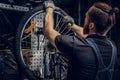 Mechanic repairing bicycle wheel tire in a workshop. Royalty Free Stock Photo