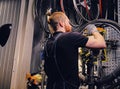 Mechanic repairing bicycle wheel tire in a workshop. Royalty Free Stock Photo
