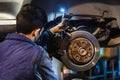 Mechanic repairing brakes on the car. Mask. Selective focus disc brake on car. Vehicle repair concept Royalty Free Stock Photo