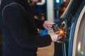 Mechanic repairing car rear light. Electromechanical workshop. Working with his hands. Tools. Concept of car repair