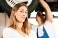 Mechanic repairing car of woman