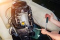 mechanic repairing inflatable motorboat engine at boat garage. Ship engine seasonal service and maintenance. Vessel motor with