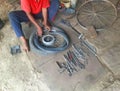 A mechanic repairing the punctured Tyre using his tools