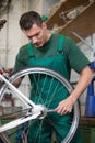 Mechanic repairing wheel on a bicycle in workshop Royalty Free Stock Photo