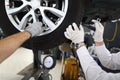 Mechanic repairing wheels, seasonal tire change