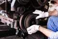 Mechanic repairs old motor of truck in a car repair station. Disassemble engine block vehicle. Motor capital repair. Car service Royalty Free Stock Photo