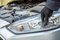 the mechanic replaces the halogen bulbs in the headlights in the car