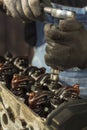 The mechanic`s hand unscrews the screw in the engine with a socket wrench. Unscrewing valve tappets and shaft. The interior of an Royalty Free Stock Photo