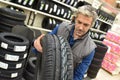 Mechanic selling tires at car store Royalty Free Stock Photo