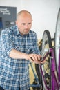 mechanic serviceman repairman installing assembling or adjusting bicycle Royalty Free Stock Photo