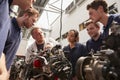 Mechanic showing engines to apprentices, low angle