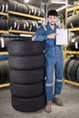 Mechanic shows blank clipboard in workshop Royalty Free Stock Photo