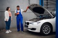 A mechanic shows the customer the engine of a car Royalty Free Stock Photo