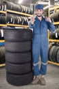 Mechanic shows OK sign in the tires shop Royalty Free Stock Photo