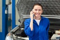 Mechanic smiling at the camera on the phone Royalty Free Stock Photo