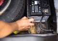 Mechanic spraying aerosol oil into iron plate for battery replacement