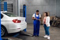 Mechanic talking to a woman about a car Royalty Free Stock Photo