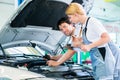 Mechanic team working in car workshop Royalty Free Stock Photo