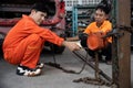 Mechanic testing strength and reliability of chain hoist for car towing. Oxus