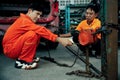 Mechanic testing strength and reliability of chain hoist for car towing. Oxus
