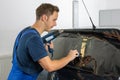 Mechanic tinting car window with tinted foil or film Royalty Free Stock Photo