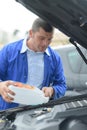 Mechanic topping up car`s screenwash Royalty Free Stock Photo