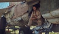 Mechanic in uniform and flight helmet carries out maintenance of an old military bomber in an open-air museum. Royalty Free Stock Photo