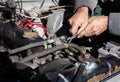 the mechanic uses a wrench to connect the hose. DIY repair. troubleshooting process. under the hood working.