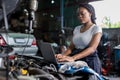 Mechanic using compute for Diagnostic  machine tools ready to be used with car. Car mechanic using a computer laptop to diagnosing Royalty Free Stock Photo