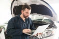 Mechanic Using Computer Diagnostic Program While Repairing Car Royalty Free Stock Photo