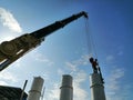 The mechanic is using the crane to install the flash dryer. with bright sky