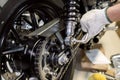 Mechanic using Hex Key Wrench or L wrench tool working on motorcycle at motorbike garage , concept of motorcycle maintenance and