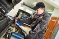 Mechanic using a hydrometer to check the antifreeze