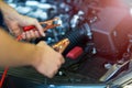 Mechanic using jumper cables to start a car