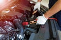 Mechanic using jumper cables to start a car Royalty Free Stock Photo