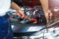 Mechanic using jumper cables to start a car