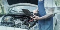 Mechanic using laptop for checking car engine, geometric pattern