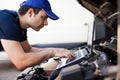 Mechanic using a laptop computer to check a car engine Royalty Free Stock Photo