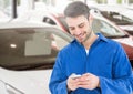 Mechanic using mobile phone in parking lot