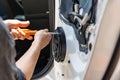Mechanic using screwdriver screwing drywall screw with car speaker on vehicle door Royalty Free Stock Photo