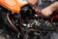 Mechanic using a wrench and socket on the engine of a motorcycle , selective focus Royalty Free Stock Photo