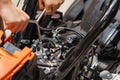 Mechanic using a wrench and socket on the engine of a motorcycle , selective focus . Royalty Free Stock Photo