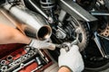 Mechanic using a wrench and socket on motorcycle sprocket .maintenance and repair concept in motorcycle garage .selective focus