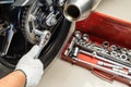 Mechanic using a wrench and socket on motorcycle sprocket .maintenance and repair concept in motorcycle garage .selective focus