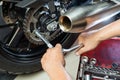 Mechanic using a wrench and socket on motorcycle sprocket .maintenance and repair concept in motorcycle garage .selective focus