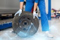 Mechanic with wheel tire at car workshop Royalty Free Stock Photo