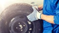 Mechanic with wheel tire at car workshop Royalty Free Stock Photo