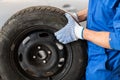 Mechanic with wheel tire at car workshop Royalty Free Stock Photo